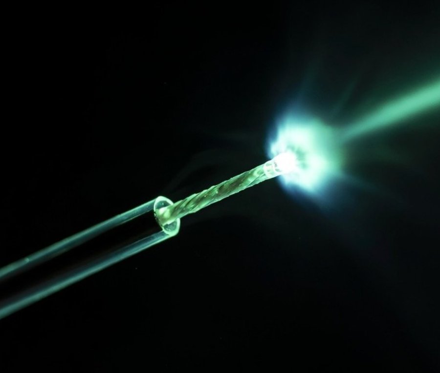 Fibra óptica con haz láser disparando — tecnología láser médica